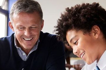 A teacher and students smiling in a classroom environment