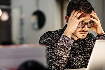 Stressed male working in front of a laptop BANNER
