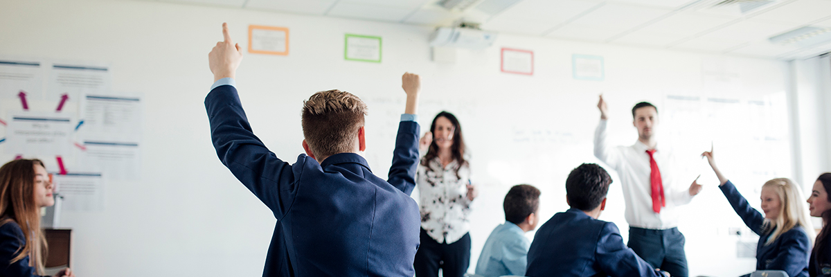 Students raise their arms in classroom BANNER
