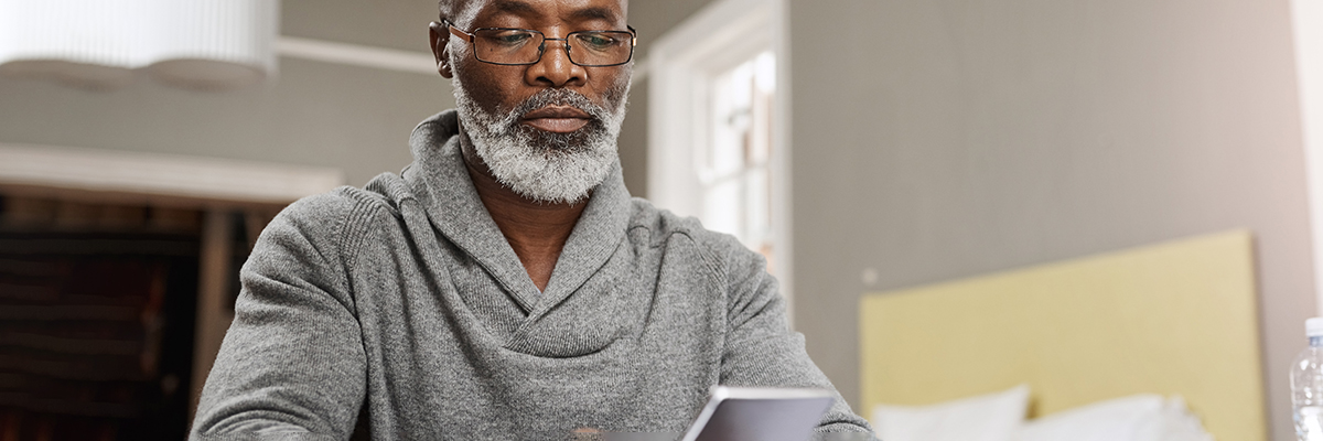 Older black man smartphone laptop calculator banking salary