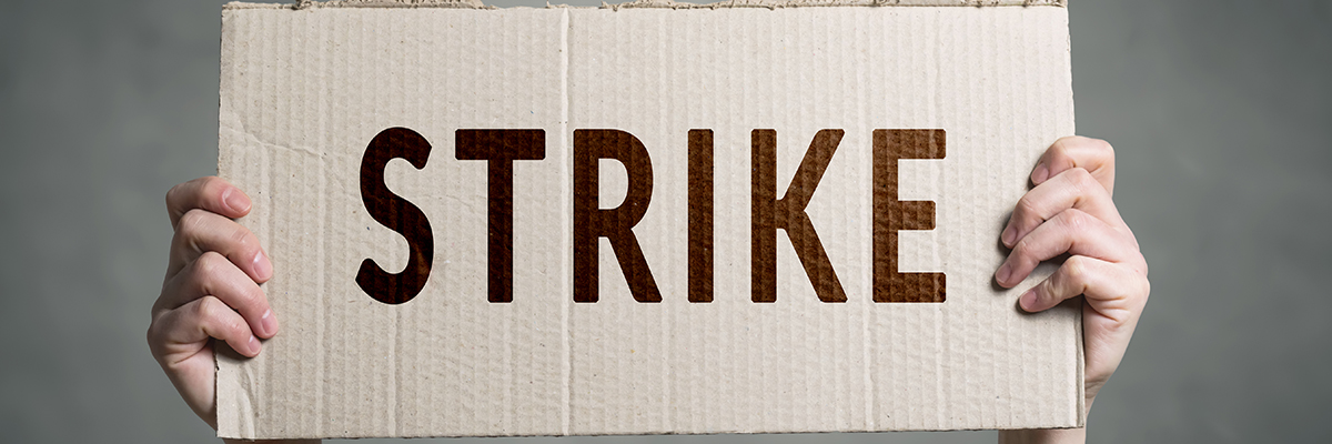 Strike cardboard placard hands white man BANNER.jpg