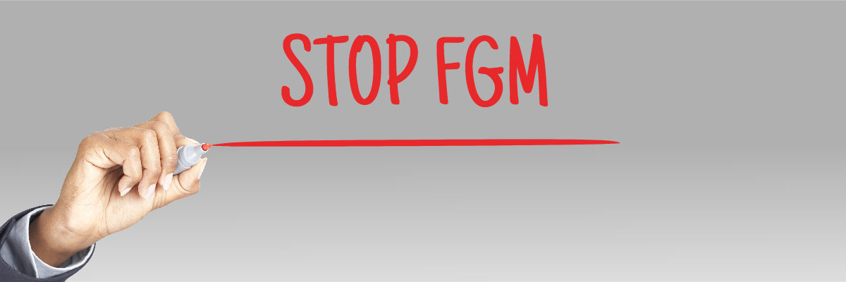 Black woman hand writing Stop FGM