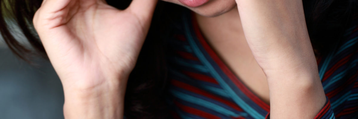 Young mixed race woman holding temples