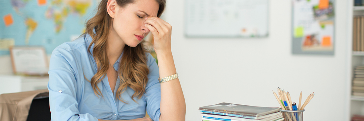 White female teacher visibly stressed in classroom BANNER